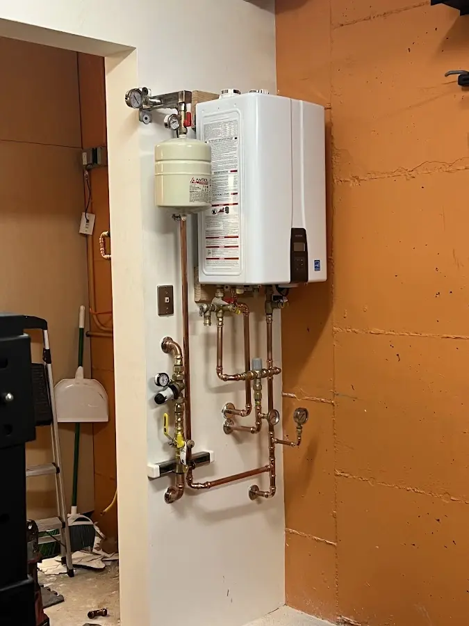 Plumbing technician inspecting water heater connections in Honesdale